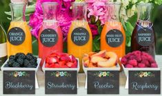 a table topped with bottles of juice and containers filled with fruit