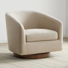 a beige chair sitting on top of a rug