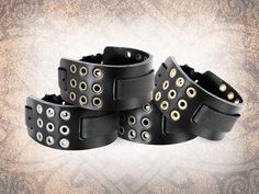 "This 1.5\" wide solid leather watch cuff is handmade from a single piece of 8 to 9 oz full-grain Italian cowhide, and is pierced by a grid of metal eyelets in your choice of finish. The SIZING option features one range of sizes in inches, and one range of sizing in millimetres. The sizing in INCHES is your WRIST SIZE, and the sizing in MILLIMETRES is your WATCH PIN SIZE. For instance, 6-7\" & 15-19 mm would fit a wrist size of 6 to 7\" and a watch pin size of 15 to 19 mm. In all cases, ensure y Adjustable Black Leather Steampunk Bracelet, Vintage Black Leather Bracelet, Black Bracelets With Rivets As Gift, Vintage Black Adjustable Watch Bands, Adjustable Black Cuff Watch Accessories, Vintage Black Bracelet With Leather Strap, Black Cuff Watch Band As Gift, Black Cuff Watch Bands As Gift, Black Cuff Watch Band For Gift