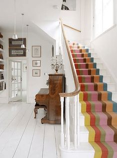 the stairs are painted multicolored in different colors and sizes, along with bookshelves