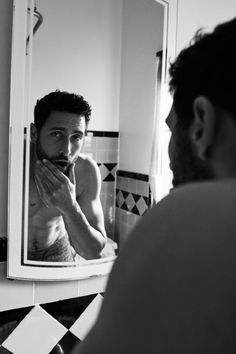 a man brushing his teeth in front of a mirror