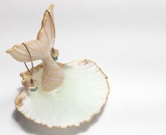 a white bird figurine sitting on top of a shell