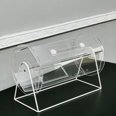 a pair of clear acrylic magazine racks on a black table next to a white wall