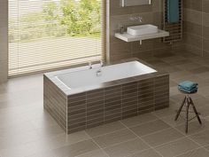 a modern bathroom with tile flooring and walls