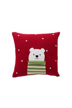 a red pillow with a polar bear in a green and white striped sweater on it