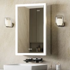 a white sink sitting under a bathroom mirror next to a wall mounted medicine cabinet and light