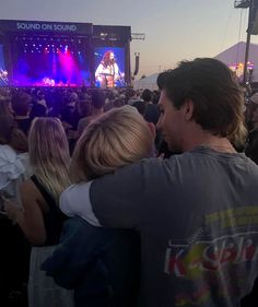 two people hugging each other in front of an audience at a music festival on stage