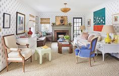 a living room filled with lots of furniture and paintings on the wall next to a fire place