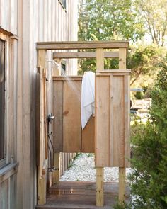 an outdoor shower in the middle of a wooden deck with white towels hanging on it