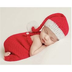 a newborn baby wearing a santa hat and sleeping