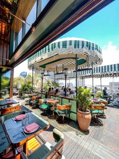 an outdoor dining area with tables, chairs and potted plants on the roof terrace