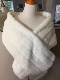 a white fur shawl on a mannequin with a mirror in the background