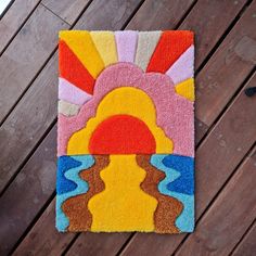 a colorful rug with an image of a sun and clouds in the center on a wooden floor