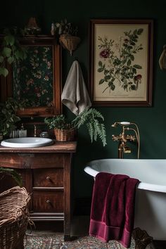 a bath tub sitting next to a white sink under a framed flower print on the wall