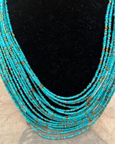 Attractive turquoise and gold beaded necklace.  18 strands, the shortest strand is 8.5 inches and the longest is 11 inches. Cheap Turquoise Long Necklace, Turquoise Beaded Necklace With Gold Round Beads, Gold Turquoise Necklace With Tiny Beads In Bohemian Style, Luxury Traditional Turquoise Beaded Necklace, Adjustable Turquoise Necklaces With Gold Beads, Bohemian Gold Turquoise Necklace With Polished Beads, Adjustable Turquoise Necklace With Gold Beads, Bohemian Gold Turquoise Necklace With Tiny Beads, Bohemian Gold Turquoise Necklace With Large Beads