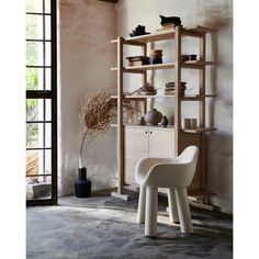 a white chair sitting in front of a wooden shelf