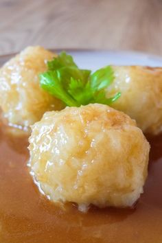 some kind of food on a plate with sauce and green leafy garnish