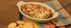 a casserole dish with cheese and crackers on the side