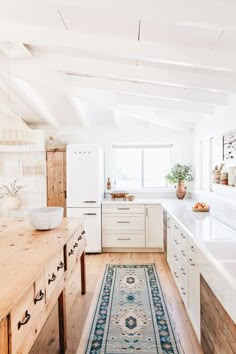 a kitchen with white cabinets and wooden floors is featured in this article by farh rug