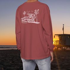 This lifeguard tower long sleeve t-shirt is the perfect way to show you support beach safety, lifeguarding, and water safety. It's made of soft, comfortable cotton and features a stylish lifeguard tower design. Whether you're a lifeguard yourself or appreciate their work, this t-shirt is a must-have. The perfect gift for you or your beach lover 🤙🏼 ABOUT: Luxurious comfort and style are what this unisex, garment-dyed sweatshirt is all about. It's made with 80% ring-spun cotton and 20% polyester Relaxed Fit Long Sleeve Beach T-shirt, Long Sleeve Tops For Beach Season Streetwear, Graphic Print Crew Top For Surfing, Long Sleeve Cotton T-shirt For Surfing, Beach Safety, Lifeguard Tower, Beach Tee, Dyed Sweatshirt, Water Safety