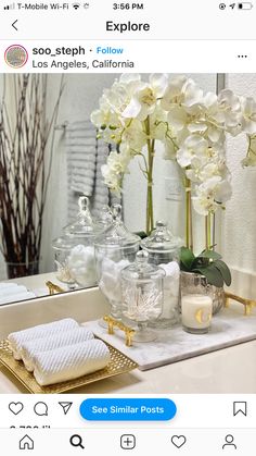 a bathroom vanity with flowers and candles on it