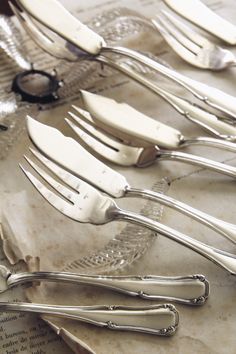 there are many forks and spoons on the table together, all in different shapes and sizes