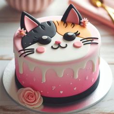 there is a cake decorated with two cats on the top and one has pink icing