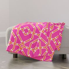 a pink and orange blanket sitting on top of a couch