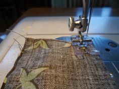 a close up of a sewing machine with a piece of cloth on it's side