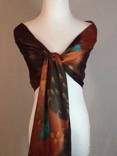 "Elegant Charmeuse Silk scarf in Dark brown, burnt orange and turquoise. 14\"x72\" Product information: Designer - Mary Jane Davidson Material- 100 % natural 19.5mm Charmeuse silk Color - any color choice Size - 14\"x72\" slight shrinkage may occur from steaming Package - Envelope or gift package This is the Porsche of silks! A muted crepe on the back side and shimmery lustrous satin on the top side. It is heavier and more substantial than plain Satin or Crepe de Chine, has a firm, soft, supple Brown Bohemian Silk Scarves, Bohemian Brown Silk Scarves, Bohemian Brown Silk Scarf, Burnt Orange And Turquoise, Silk Scarf Painting, Hand Painted Silk Scarf, Painted Silk, Mild Shampoo, Orange And Turquoise