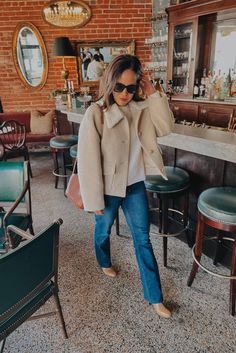 Woman wearing a boulce coat and jeans in a front of a bar. Parisian Style Winter Chic, Parisian Style Winter, French Wardrobe Essentials, Wool Coat Outfit, French Holiday, French Wardrobe