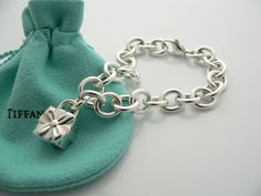 Offered for sale is a wonderful and super cute Tiffany and Co. Sterling Silver Signature Gift Box Charm bracelet. The piece is made from substantial and bright Tiffany silver, and yet retains a very feminine feel to it. Attached to its very substantial and bright Tiffany Silver charm bracelet is a super Cool Signature Gift Box Padlock charm. The Gift Box padlock charm opens and closes, and thus can be used as a charm on a necklace or as part of another charm bracelet! Super versatile piece! It i Luxury Silver Jewelry For Birthday Gift, Luxury Silver Jewelry With Original Box, Elegant Sterling Silver Bracelet With Box Clasp As Gift, Rectangular Bracelet With Box Clasp For Gift, Sterling Silver Bracelet With Box Clasp As Gift, Rectangular Bracelet With Box Clasp As Gift, Luxury Rectangular Jewelry Gift, Luxury Sterling Silver Chain Bracelet Gift, Luxury Jewelry With Gift Box