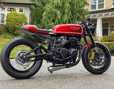 a red motorcycle parked in front of a house