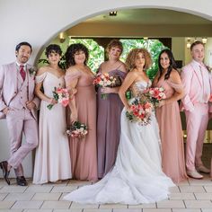 a group of people standing next to each other in front of a doorway with flowers