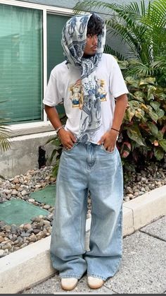 a man standing in front of a house with his hands on his hips