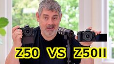 a man holding up two cameras in front of him and the words zoom vs z50 on