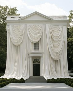 a large white building with curtains on it's sides