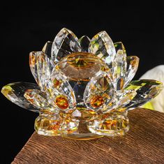 a crystal flower sculpture sitting on top of a wooden table