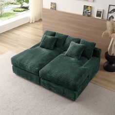 a large green couch sitting on top of a white rug