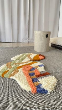 a pile of rugs sitting on top of a carpet next to a toilet paper roll