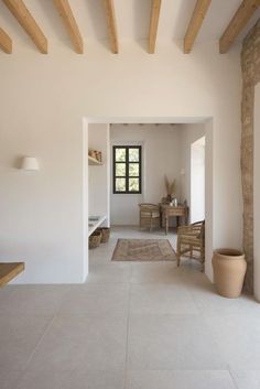 an empty room with white walls and wooden beams