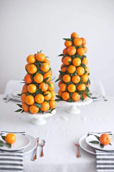 there are three oranges on the table with forks and knives in front of them