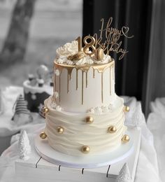 a white and gold wedding cake on top of a table