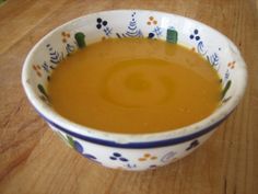 a bowl filled with soup sitting on top of a wooden table