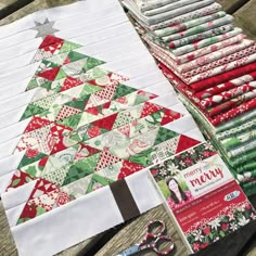 a quilted christmas tree sitting on top of a wooden table next to scissors and other items