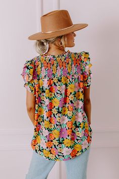 - Embrace feminine florals this season with this sweet top! - Unlined material with a colorful floral print - A ruffled v-notched neckline - A smocked upper bodice - Short flutter sleeves - A relaxed silhouette that ends in a rounded hemline Spring Floral Print V-neck Smocked Top, Multicolor V-neck Tops With Ditsy Floral Print, Black Tops With Smocked Back For Vacation, Black Top With Smocked Back For Vacation, Spring Multicolor Smocked Top With Ruffles, Multicolor Smocked Top With Ruffles For Spring, Casual V-neck Smocked Top With Floral Print, Summer Multicolor Smocked Top With Floral Print, Summer Multicolor Floral Print Smocked Top