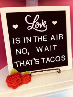 a sign that says love is in the air no wait that's tacos