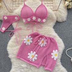 two pieces of pink crochet swimsuit with white flowers on the bottom and side