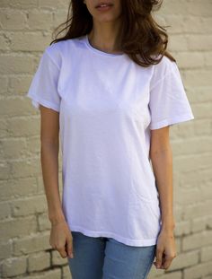 Our Classic White Unisex Tee is made from an extremely soft, lightweight jersey out of 100% cotton fibers. Style details include a crew neck and clean finished hems. Classic fit. Additional Information: * 100% Cotton * Made in USA * Length: 25 3/4 in. (XS) * Model wears size XS * Machine wash cold with like colors, tumble dry low * This item is unisex sizing. We recommend men order their normal size and women size down for a more fitted look Look Plus, Classic White, Cotton Fiber, Unisex T Shirt, Made In Usa, Bathing Beauties, Adult Outfits, Angeles, Womens Sizes