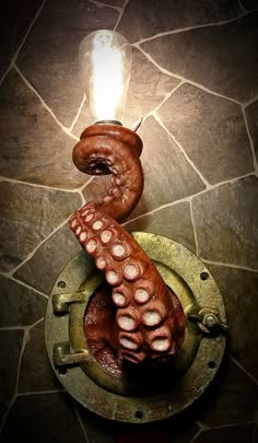 an octopus lamp sitting on top of a stone floor next to a lightbulb